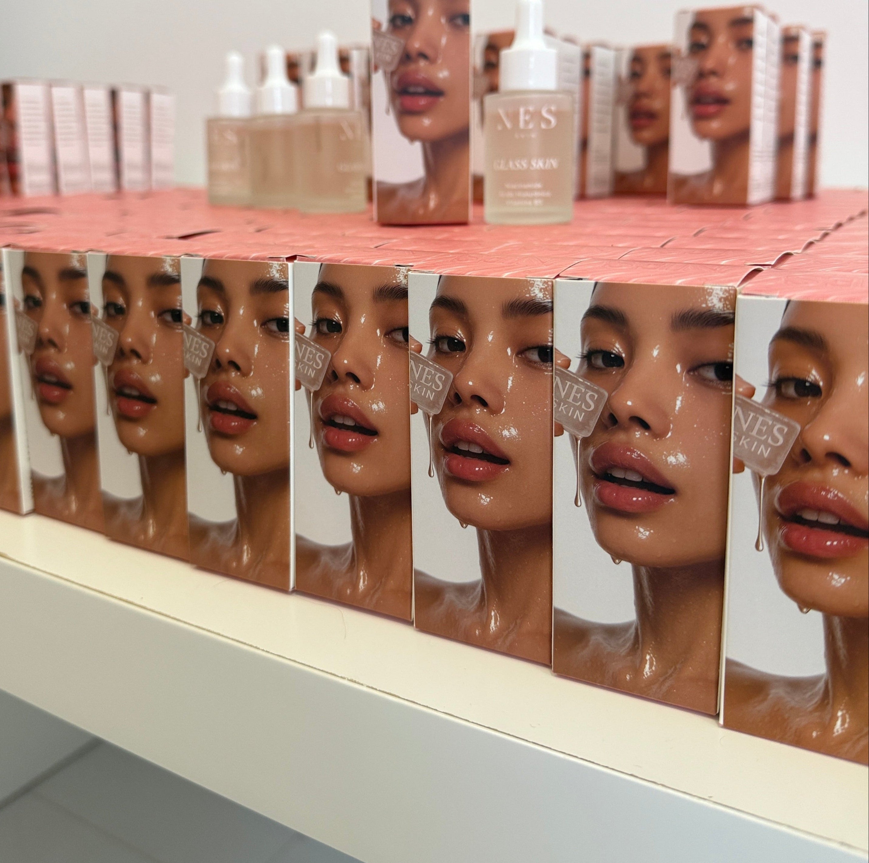 Multiple bottles of a skincare product with a mirror reflection on a white background